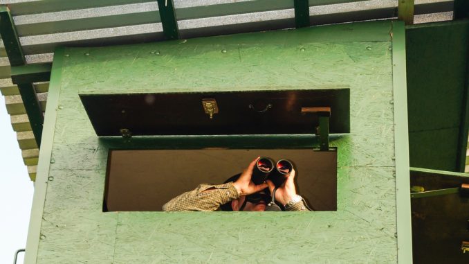 Jäger im Ansitz mit einem Fernglas