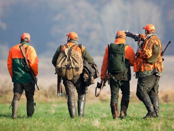 Vier Jäger sind auf dem Weg zur Treibjagd.